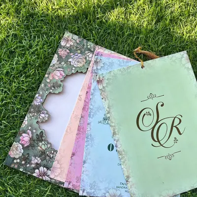 The full experience of a laser-cut invitation. When fanned out, you can see how the intricate floral frame of the cover perfectly complements the pastel-colored inserts for each event.