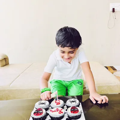 The birthday boy, Ram, getting ready to make a wish on his 5th birthday. His custom Spider-Man cupcakes are all lined up, showing the complete themed set that includes his name and age.
