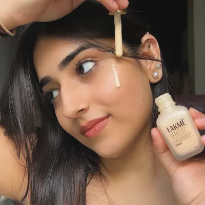 A close-up shot demonstrating the Lakmé Perfect Radiance Serum. I focus on showing the product's texture and application to highlight its skincare benefits, like fading pigmentation with Niacinamide.