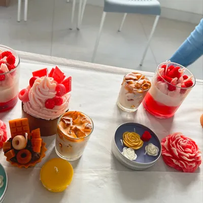 A beautiful spread of finished dessert and floral candles from one of our workshops. You can learn to make a variety of styles, including cupcake candles, macaron candles, and layered jar candles.