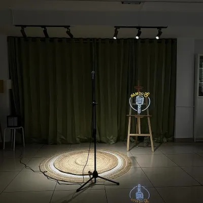 The stage is set. Our simple yet professional setup with a spotlight, mic, and backdrop is perfect for intimate gigs and stand-up shows.