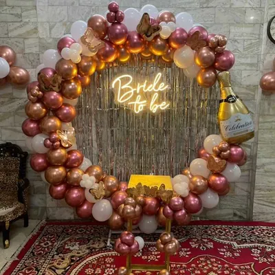 A popular choice for bridal showers, this circular frame is covered in rose gold and white balloons. The design is elevated with a "Bride to be" neon sign and a large champagne bottle foil balloon for a fun, celebratory touch.