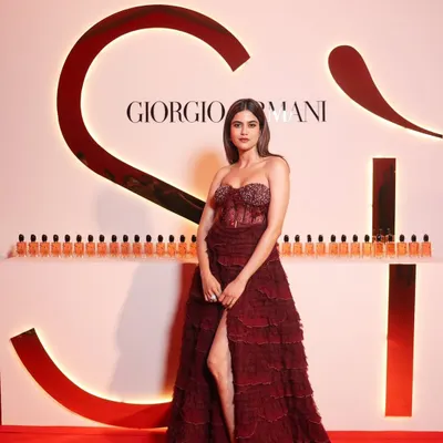 A full-length shot of Aaditi Pohankar at the Giorgio Armani event. The deep red gown called for a powerful makeup look with a bold lip and sculpted eyes.