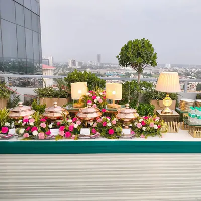 An exquisite rooftop buffet with a panoramic view of the city. We use a combination of ambient lighting, floral decor, and elegant serveware to create a luxurious dining experience.