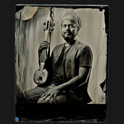 A wet plate collodion portrait of a musician with his instrument. The process renders a striking level of detail and a powerful presence, creating an image that feels both immediate and historic.