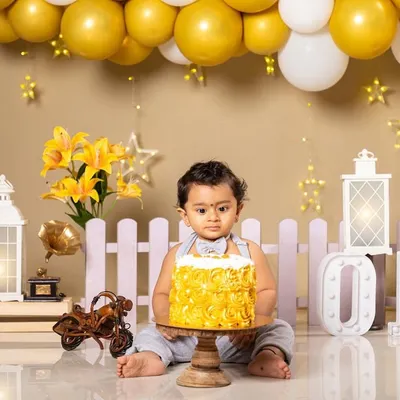 The moment of anticipation just before the cake smash begins. I set up this entire scene with a yellow and white theme, including the 'ONE' marquee letters, lanterns, and a perfectly sized cake for smashing.