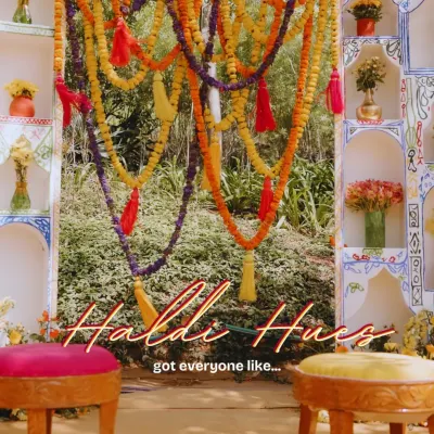 The focal point of a vibrant Haldi ceremony, this backdrop features a traditional 'jhoola' (swing) adorned with colorful marigold garlands and tassels, creating the perfect spot for the main ritual.