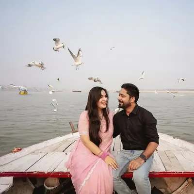 An iconic shot from our Banaras pre-wedding series. The couple shares a laugh on a boat as seagulls fly around them, creating a magical and spontaneous moment.