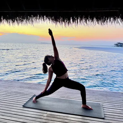 Holding Reverse Warrior pose against a beautiful sunset. This pose strengthens the legs and core while creating a beautiful side body stretch, making you feel both powerful and peaceful.