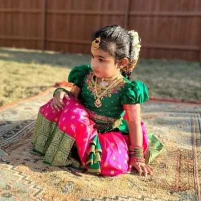 A beautiful shot of a custom-designed Pattu Pavadai in green and pink. I used pure silk and added delicate embroidery on the puffed sleeves to give it a rich, couture feel perfect for a little princess.