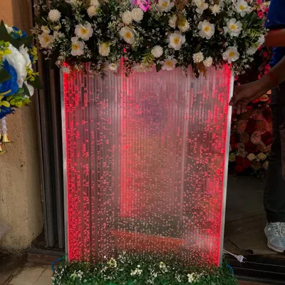 Add a touch of tranquility to your Ganpati setup with this unique waterfall feature. Measuring 3x2 ft, this element has bubbling water and changing LED lights, topped with a floral arrangement. It creates a serene and magical ambiance.