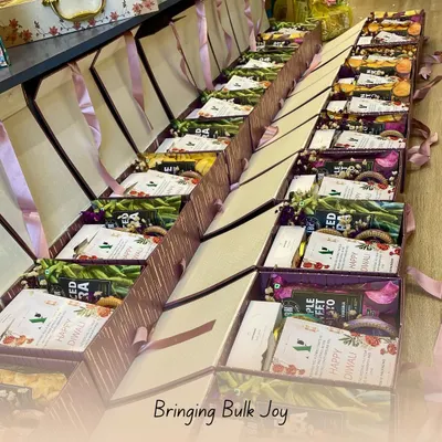 This image shows a lineup of Diwali hampers ready for a corporate client. Each box is consistently packed with a selection of healthy snacks and a personalized "Happy Diwali" card, ready for distribution.