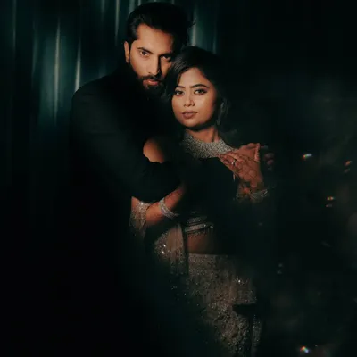 A moody and dramatic portrait of a couple. The dark background and focused lighting create a sense of intimacy and intensity, perfect for a cinematic feel.