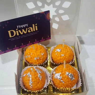 This gift box contains four of my signature Motichoor Ladoo candles. Each one is handcrafted to look just like the real sweet, complete with silver leaf detail, and made with scented soy wax for a clean burn.