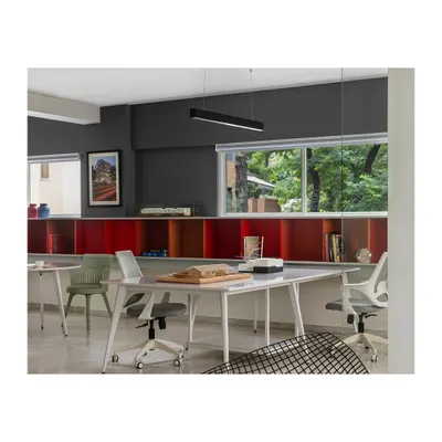 Our Pune studio, located in the leafy neighborhood of Koregaon Park. The workspace is organized around a long shelving unit in red, yellow, and blue, which houses our library of architectural books and models, reflecting our vibrant and intellectual design approach.