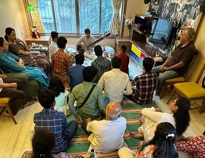 A classic 'baithak' at a private residence. The audience is seated close, creating a cozy and informal atmosphere where they can truly connect with the music.