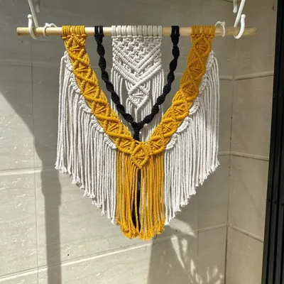 A full view of our custom three-layered macrame wall hanging. The combination of intricate knots and layered colors creates a piece with amazing depth and texture, perfect for a statement wall.