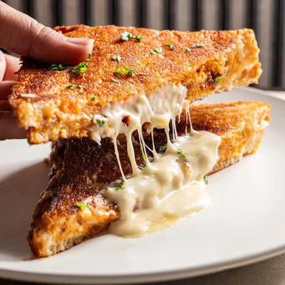 The anatomy of a perfect grilled cheese sandwich. Capturing a cheese pull like this is a guaranteed way to boost engagement on social media.