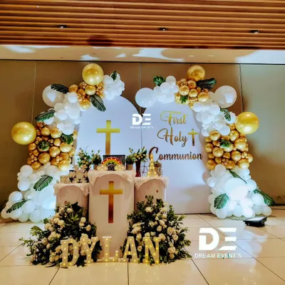 A beautiful and blessed setup for Dylan's First Holy Communion. We used elegant white and gold balloon arches, floral arrangements, and marquee lights to create a heavenly atmosphere.