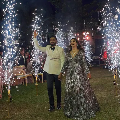 The couple makes a grand entrance at their bohemian-themed reception, walking through a tunnel of sparklers. The bride's shimmering gown and the groom's classic tuxedo look perfect against the magical backdrop.