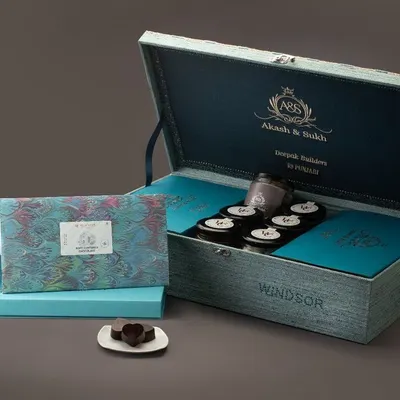 This custom wedding box for 'Akash & Saloni' is a prime example of my luxury gifting service. It features a personalized wooden chest, custom inserts, and a curated selection of our finest couverture chocolates, making it a perfect wedding announcement or favor.