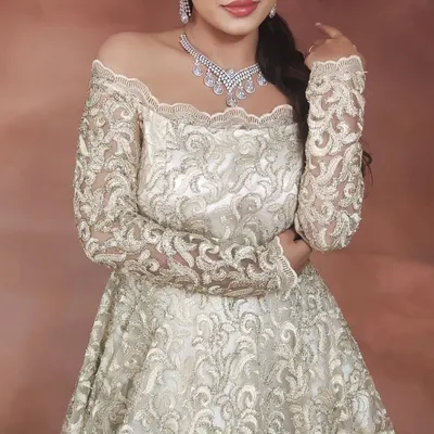 This elegant off-shoulder gown with intricate lacework is perfect for a sophisticated reception or cocktail party look. It pairs beautifully with a simple diamond necklace.