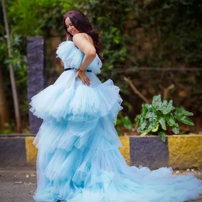 A full view of our dreamy light blue tiered ruffle gown. The layers of tulle create a cloud-like effect that moves beautifully, and the long train adds that extra touch of drama for an unforgettable outdoor maternity photo.