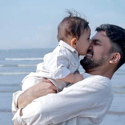 A tender moment between father and son on the beach. The natural light and ocean backdrop create a timeless and heartfelt portrait.