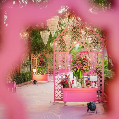 I transformed this outdoor space into a pink paradise for a Mehendi ceremony. Intricate jaali arches, chic chandeliers, and lush floral arrangements create a dreamy and whimsical atmosphere.