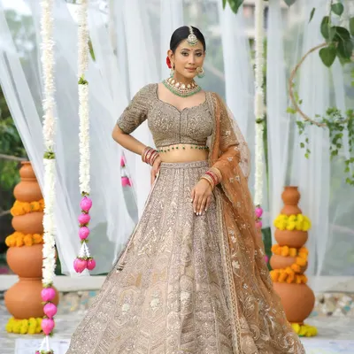 Timeless elegance that will keep winning hearts. This bride looks absolutely stunning in a beige and gold lehenga, with a soft-glam makeup look that enhances her natural beauty.
