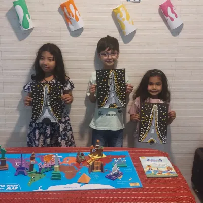 Proudly showing off their Eiffel Tower paintings. Our Wonders of the World session combined learning about global landmarks with a fun dot painting art activity.