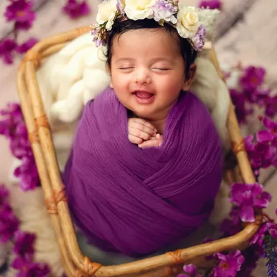 A sleepy smile is one of the most precious gifts from a newborn session. I love capturing these fleeting moments of pure contentment, wrapped cozily in a vibrant purple swaddle.