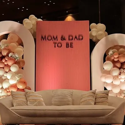 A chic and modern stage for the 'Mom & Dad to Be'. This setup features cascading organic balloon garlands in earthy tones, set against clean, arched backdrops for a sophisticated teddy bear themed baby shower.
