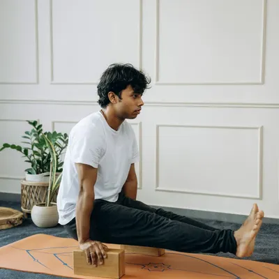 A yoga block isn't a crutch; it's a bridge. Here, it helps build the core and arm strength needed for L-sit (Brahmacharyasana), making a challenging arm balance more approachable.