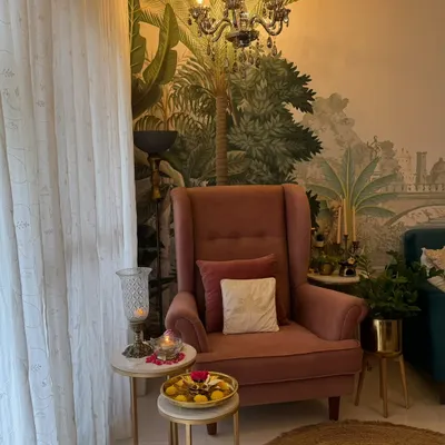 This is my favorite wingback chair, styled as a cozy reading nook. With a side table for my laddus and a candle for ambiance, it's the perfect place to unwind.
