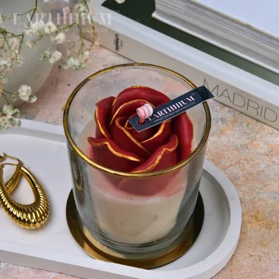 This is my floral votive glass jar candle in a deep, romantic red. The rose is hand-sculpted from wax, and the petals are tipped with gold for an elegant finish.