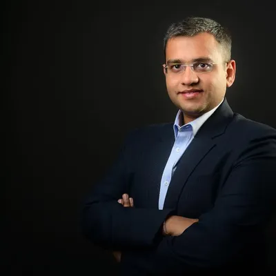 A classic corporate headshot against a solid dark background. This style provides a clean, timeless, and professional look, ideal for LinkedIn profiles, company directories, and speaker bios.