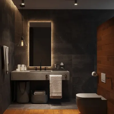 A sophisticated bathroom with dark slate tiles and wooden flooring in the dry area. The space features a floating concrete vanity and a backlit mirror, creating a warm, ambient glow.