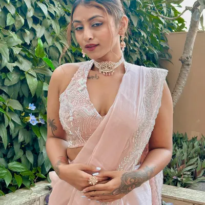 A closer look at this modern festive outfit. The heavily embroidered halter blouse paired with a simple, elegant pink saree and a statement choker creates a balanced and sophisticated Indian wedding look.