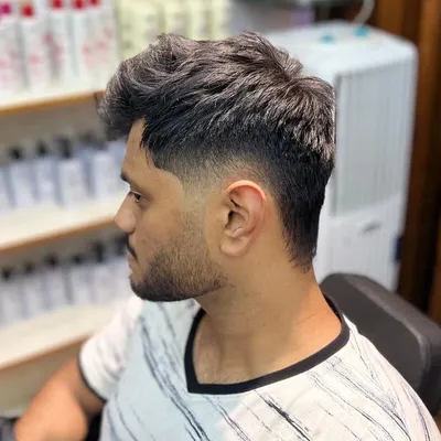 This is a classic taper fade, a very popular men's haircut. We kept the top longer for styling versatility while fading the sides and back for a clean, sharp finish.