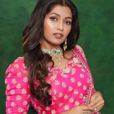 A beautiful "no-makeup" makeup look perfect for daytime events. The focus is on glowing skin, subtly defined eyes, and a neutral lip color, all while wearing a gorgeous pink lehenga.