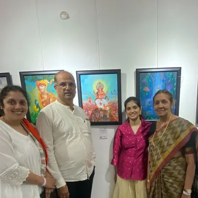 A student and her family posing proudly with her Ganesha painting at the CHITRAKAR art exhibition.