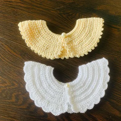 A versatile set of two detachable collars in classic white and cheerful yellow. Each is handcrafted with a scalloped edge and a single pearl button, making it easy to attach and remove for a quick style change.