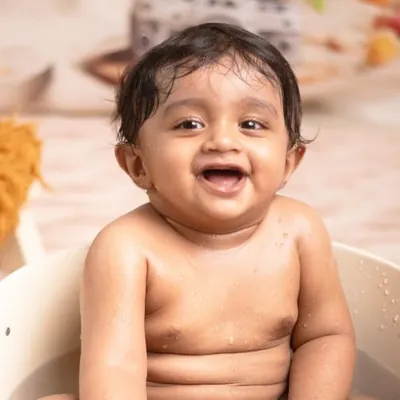 Just look at that happy face! This close-up from a beach-themed tub session captures the pure delight of playing in the water. These are the authentic, joyful moments I love to photograph.