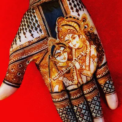 A stunningly detailed portrait of Radha and Krishna on the palm. The use of shading and fine lines brings the divine couple to life, making it a masterpiece of henna art.