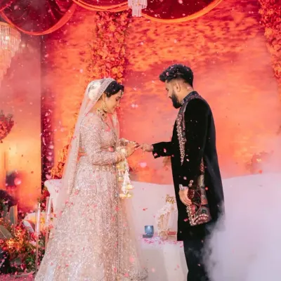 A moment of promise, captured in couture. The bride's heavily sequined lehenga and the groom's black velvet sherwani with detailed embroidery are designed to be a perfect pair for their engagement ceremony.