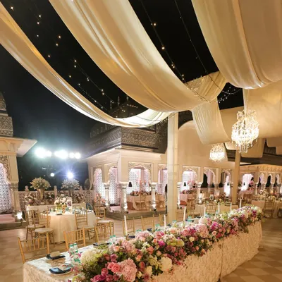 The transformation from pheras to reception. In just four hours, the ceremony space was converted into an elegant seated dinner for 190 guests, with long banquet tables, lush floral runners, and soft, romantic lighting.