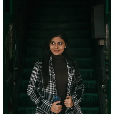 A moody portrait taken on a dark staircase. I love using shadows and ambient light to create a sense of atmosphere and focus on the subject's expression.