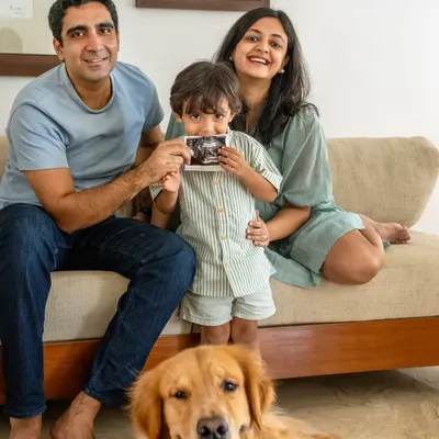 The whole family together, eagerly awaiting their newest member. Here, Ziggy the Golden Retriever joins his family for a maternity announcement, with his human brother proudly showing the sonogram.