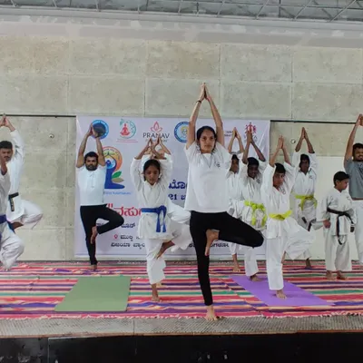 Our students, from young children to adults, practicing Vrikshasana (Tree Pose) on stage during an International Day of Yoga event. Balance is a key skill we cultivate in our martial arts training.